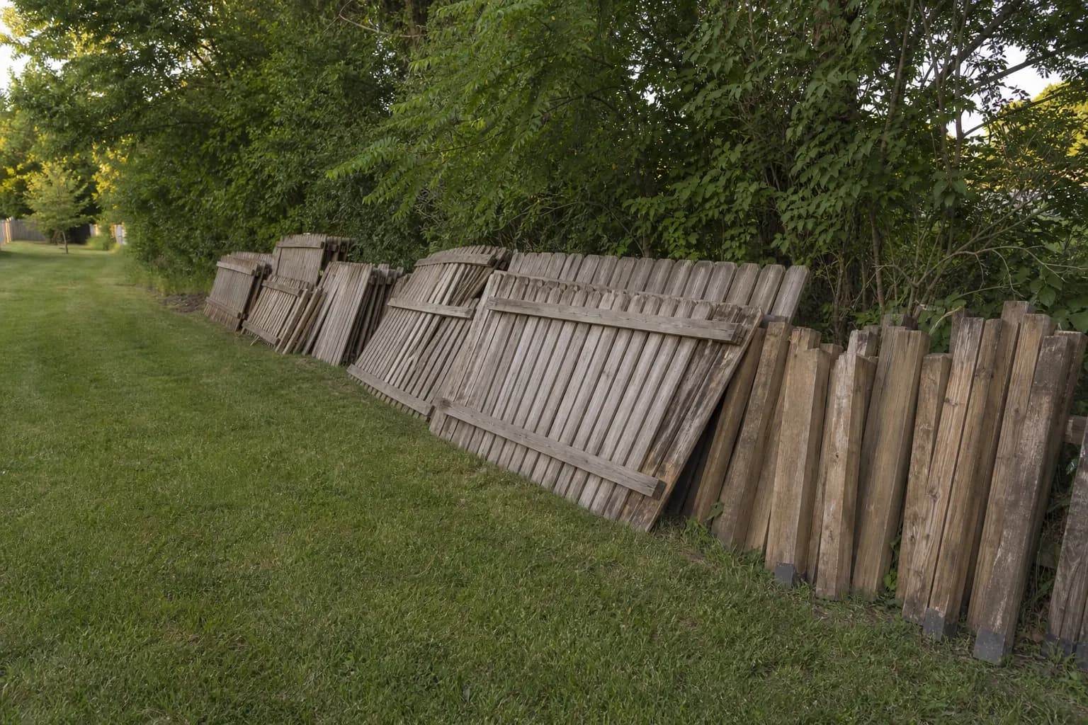 Fence Removal Fence panels and posts stacked for haul-away after fence removal